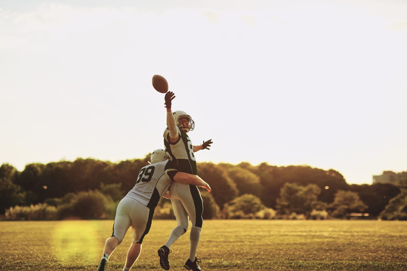 Zuspiel im American Football, ein Spieler nimmt den Ball auf
